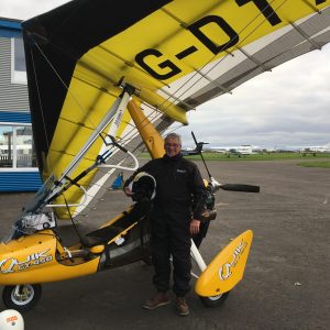 Man standing in front of flexwing microlight